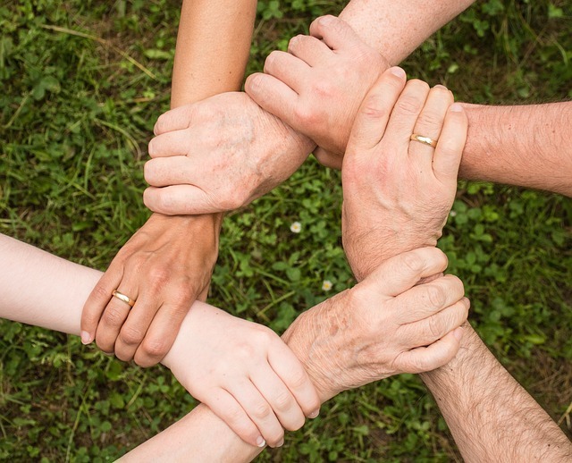 An image symbolizing unity and togetherness, featuring a circle of hands of diverse skin tones clasped over a vibrant green backdrop, reminiscent of the harmonious and thriving community spirit in Bulacan